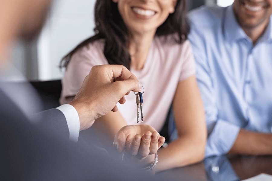 realtor handing new house keys to clients 