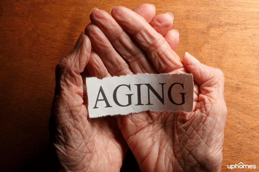 A Senior, elderly woman holding a sign that says aging with wrinkles in her hands and fingers