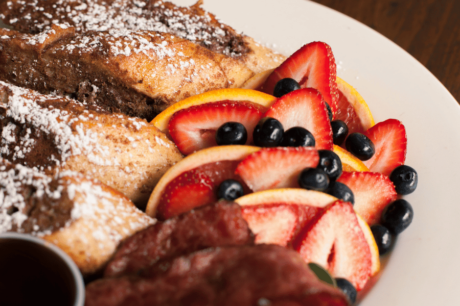 Brunch with fruit, french toast, and bacon 