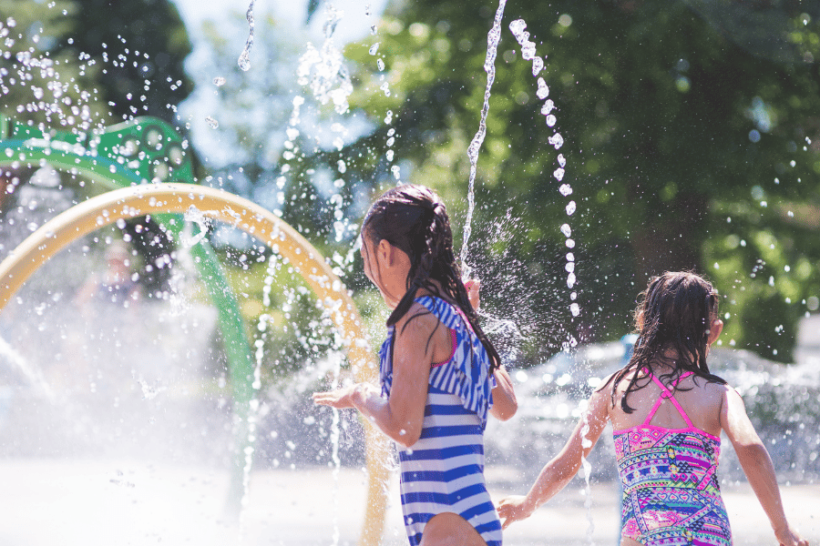 splash-pad.png children playing in splash pad with sprinklers