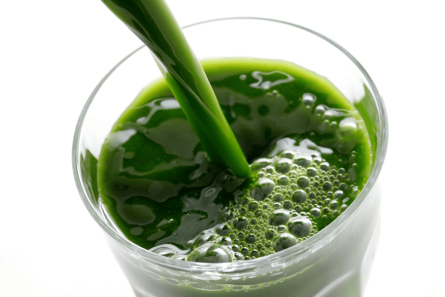 Green juice poured into a glass 
