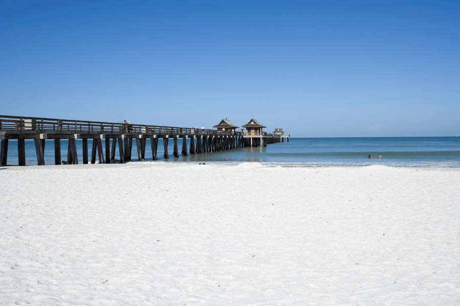 Naples Pier Beach on a sunny day with white sand 