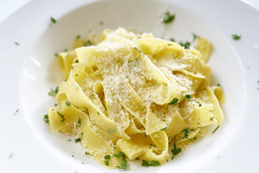 Fettuccine Alfredo dish in a bowl with parmesan cheese